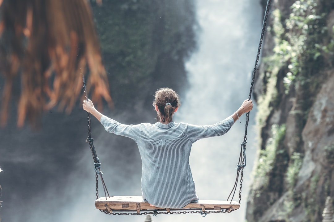 Beautiful woman swings near waterfall in the jungl