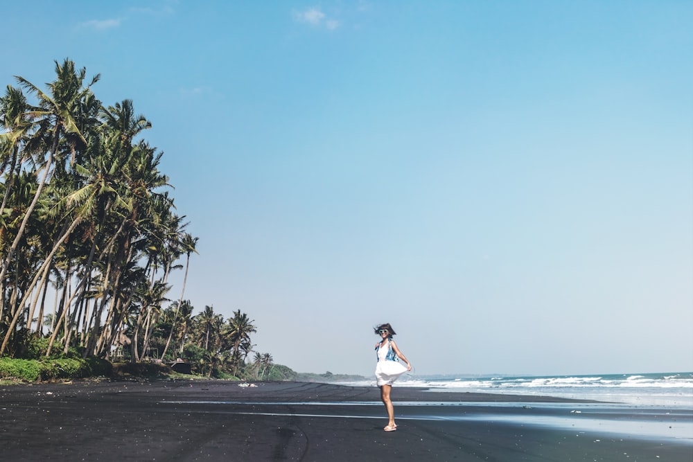 woman standing on beach during daytime