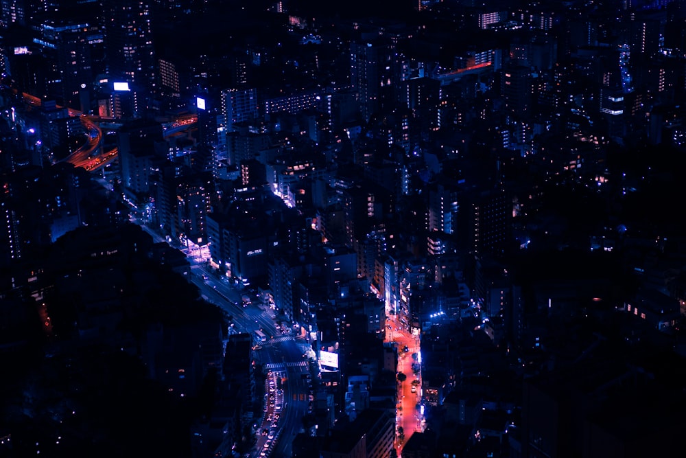 Fotografia com vista aérea de edifícios iluminados da cidade durante a noite