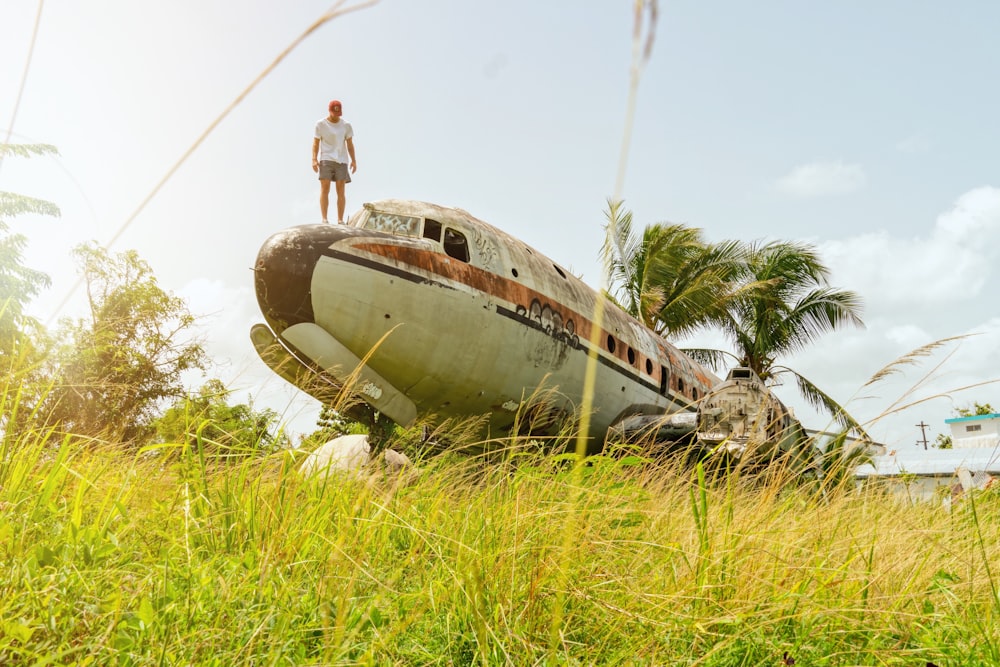 person standing on wrecked white and brown aircraft