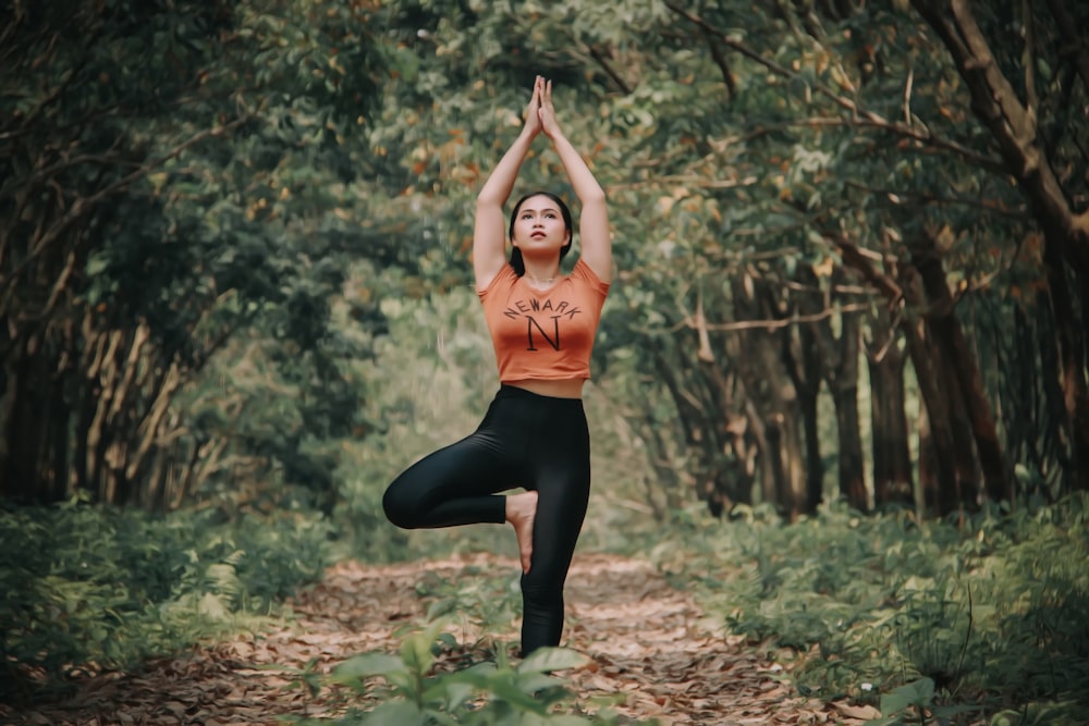 Frau macht Yoga in der Nähe von Bäumen