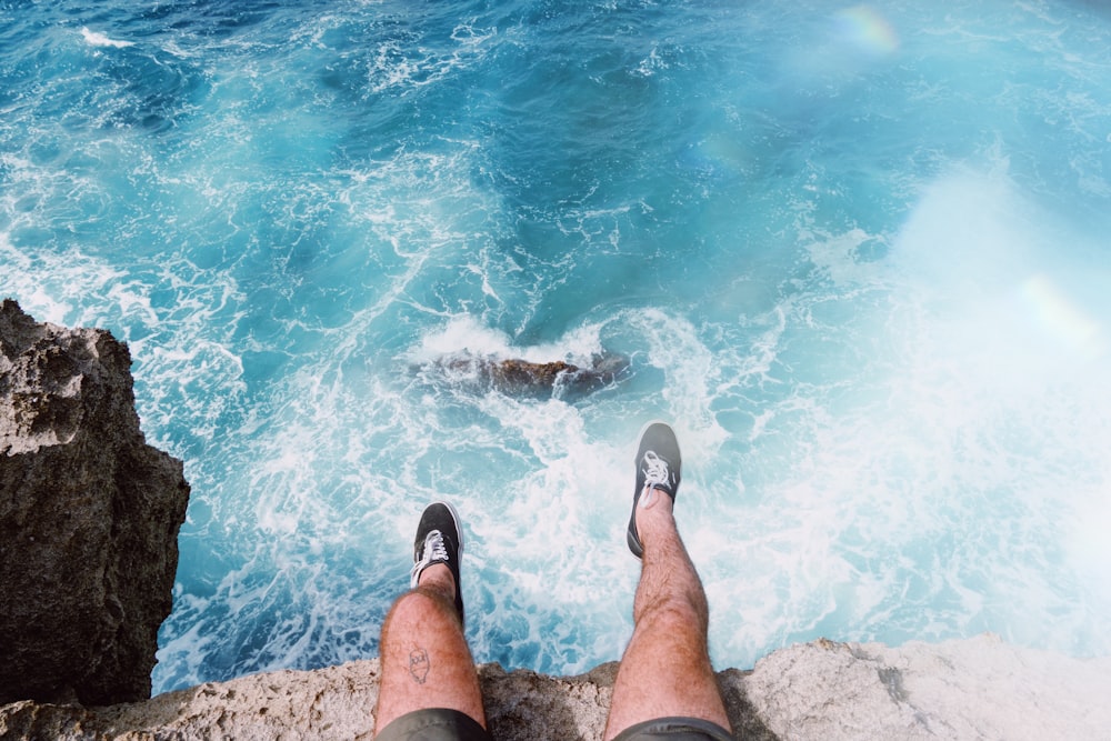 man sitting on the edge of a cliff