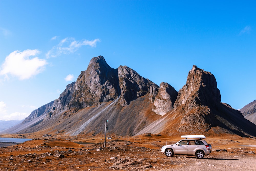 grauer SUV in der Nähe von Felsklippen geparkt