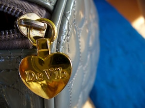 Close-up of a luxurious heart-shaped bag with intricate detailing on a soft velvet background.