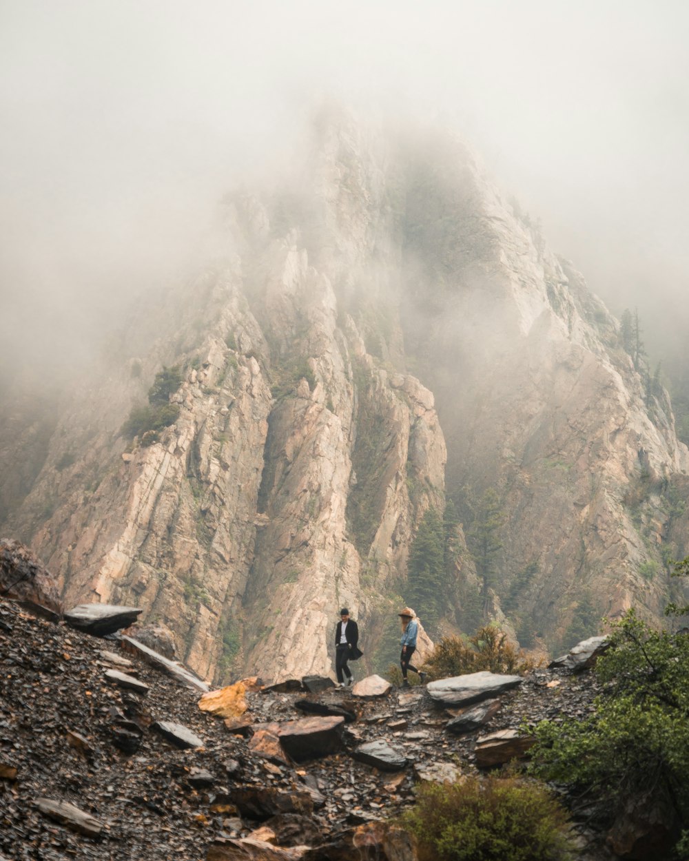 two person walking near rock formation