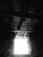 High-contrast monochrome image of vintage wooden beams inside renovated space.