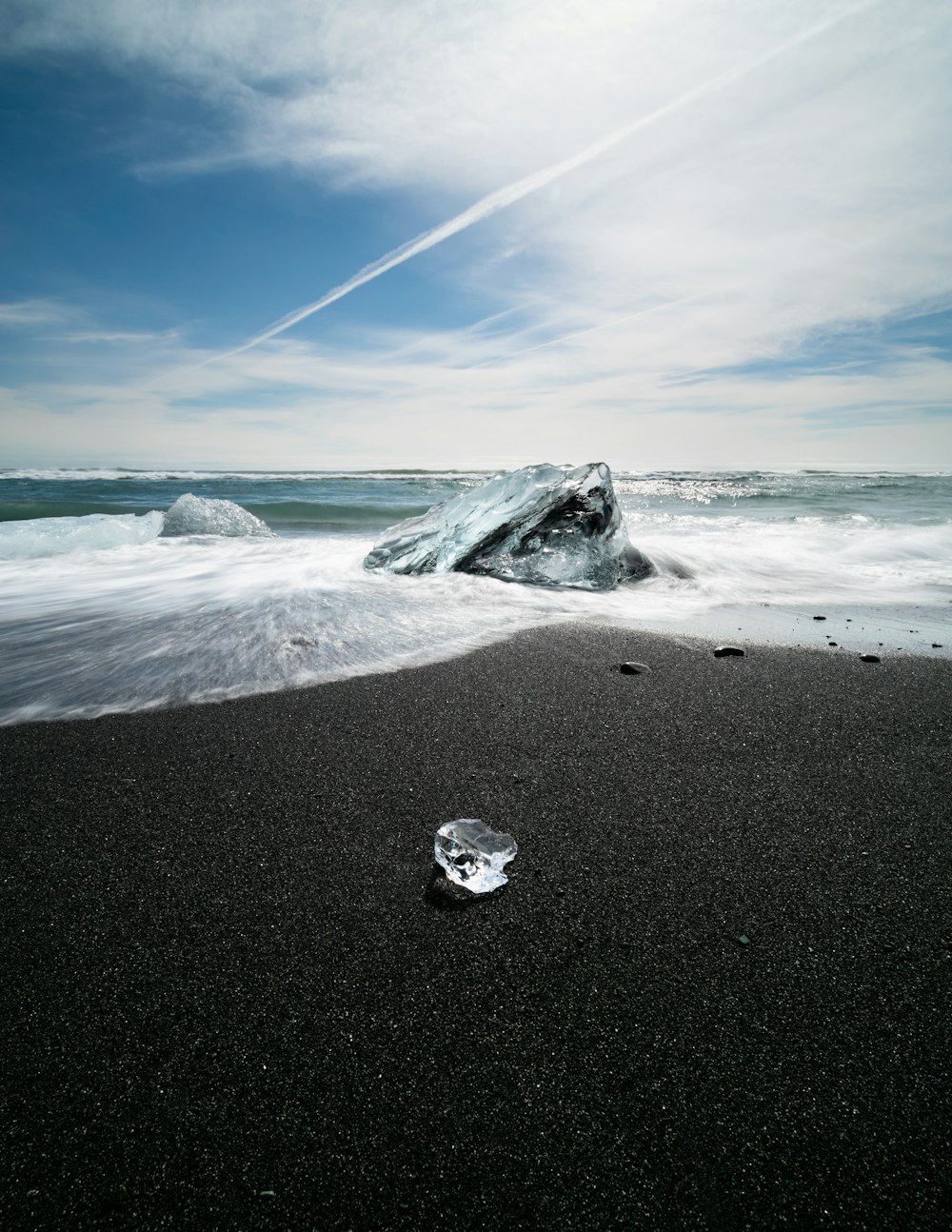 ice on grey shore under blue and white sy