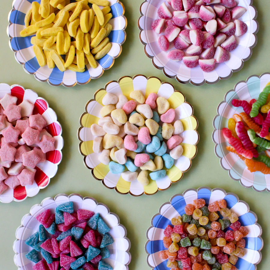 A vibrant assortment of colourful candies arranged on scalloped plates