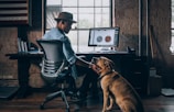 man sitting on rolling chair holding dog