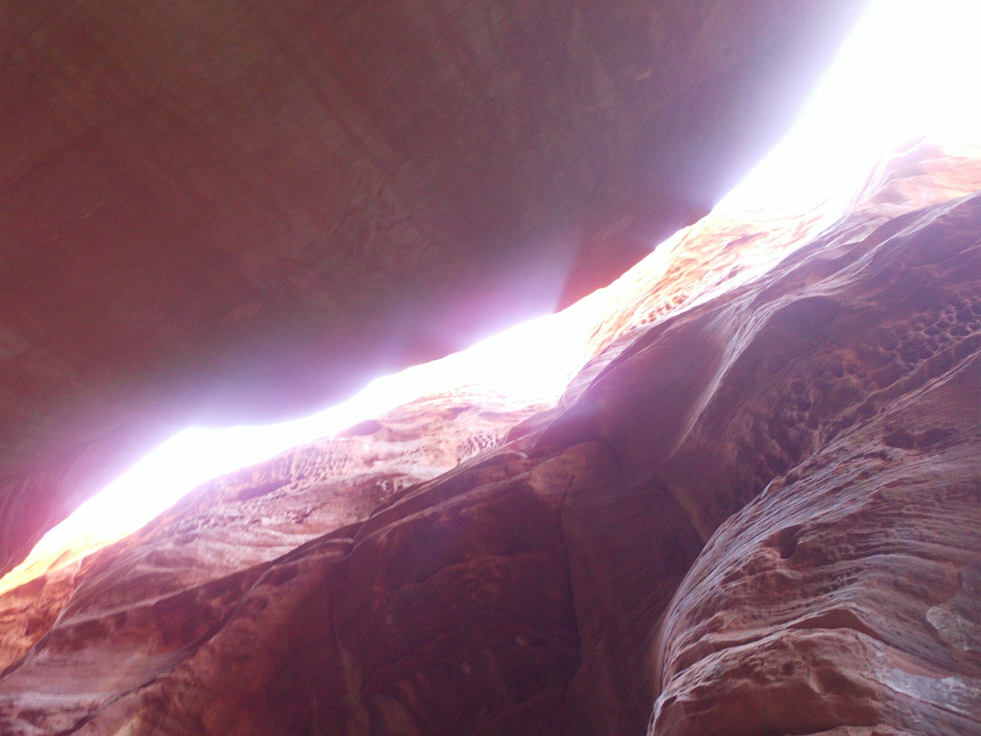 View looking up at towering canyon walls with sunlight filtering through, capturing the spirit of adventure in Innsbruck.