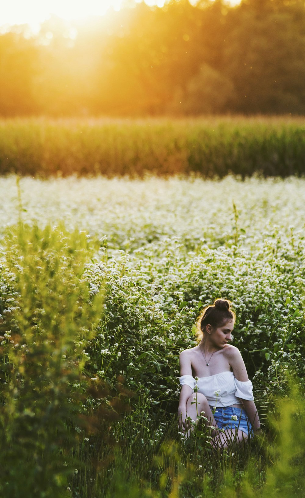 golden hour photography of woman in white top and blue denim shorts