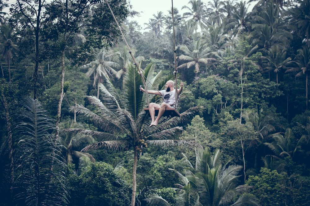 man swinging on brown swing