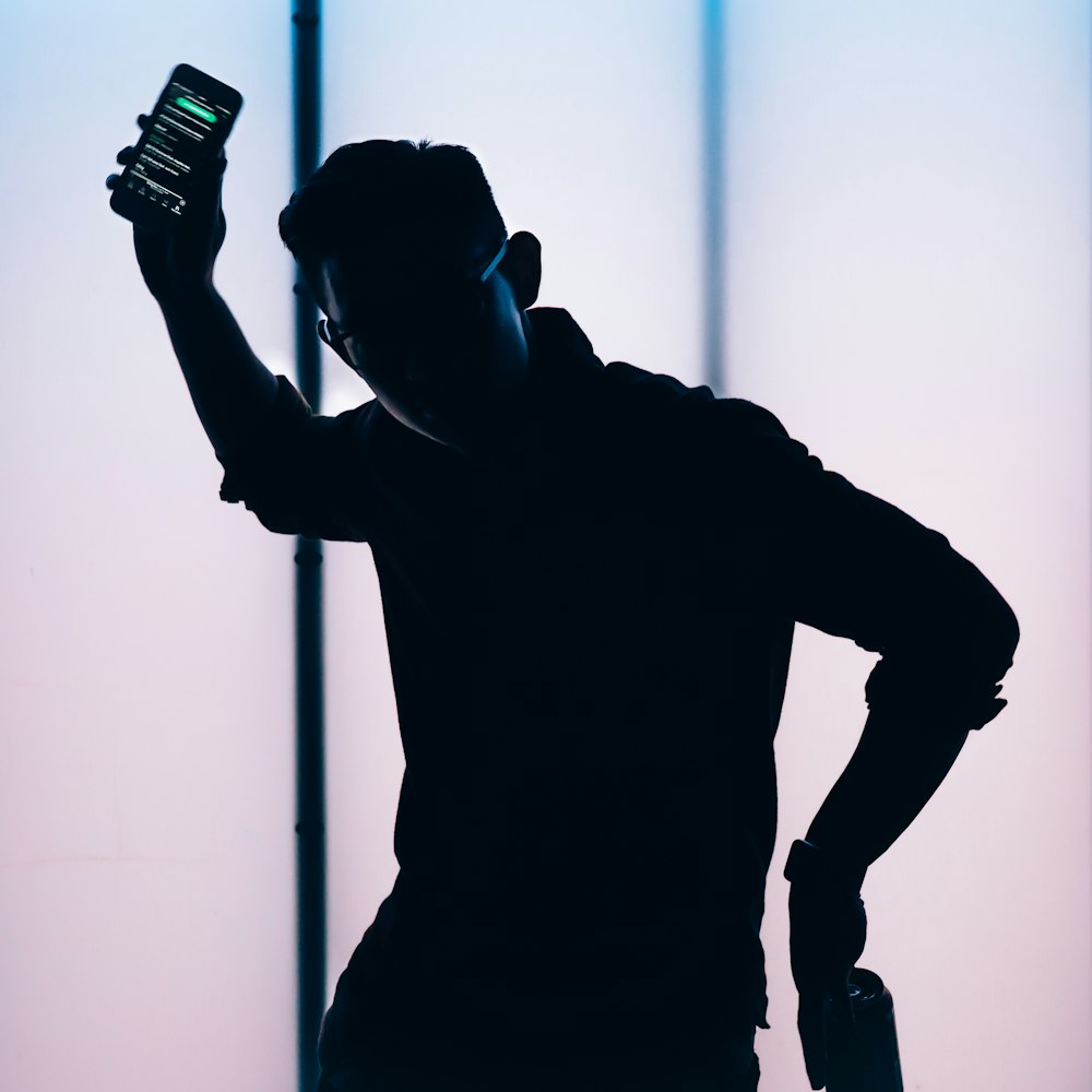 silhouette of man holding smartphone