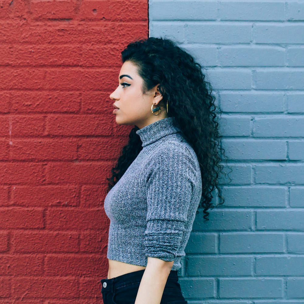 femme debout au milieu sur le mur peint rouge et gris