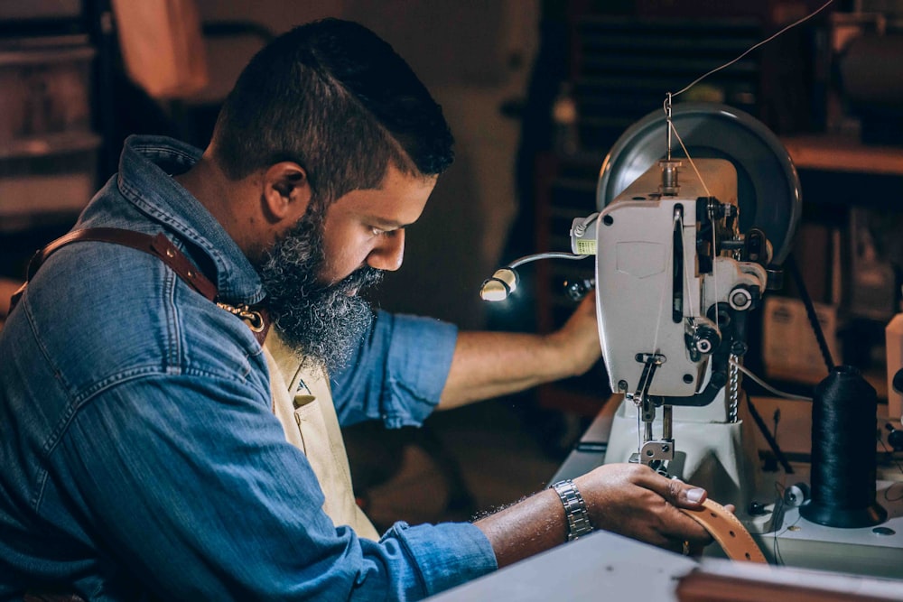 man sewing brown belt