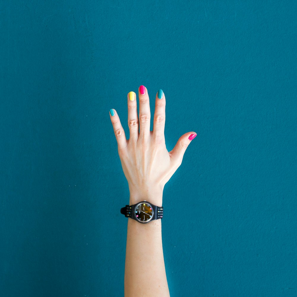 Personne portant une montre analogique ronde noire avec bracelet noir