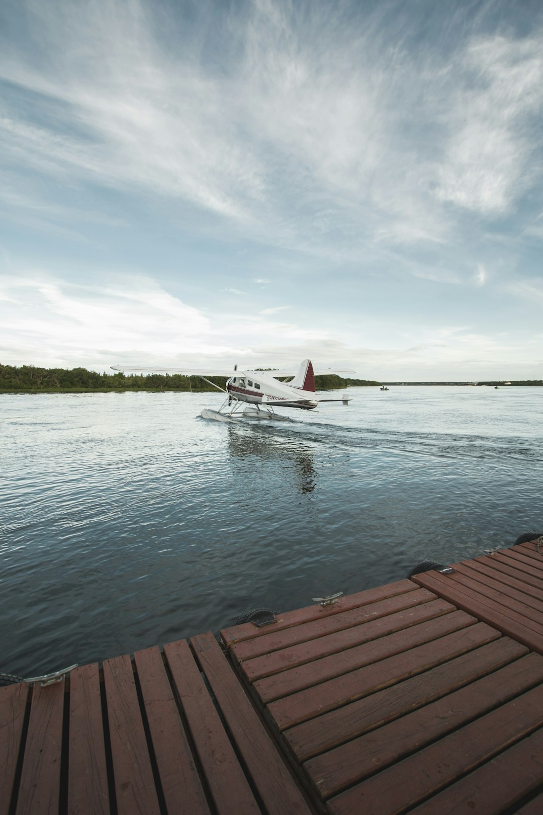 white and red airplane taking off from water