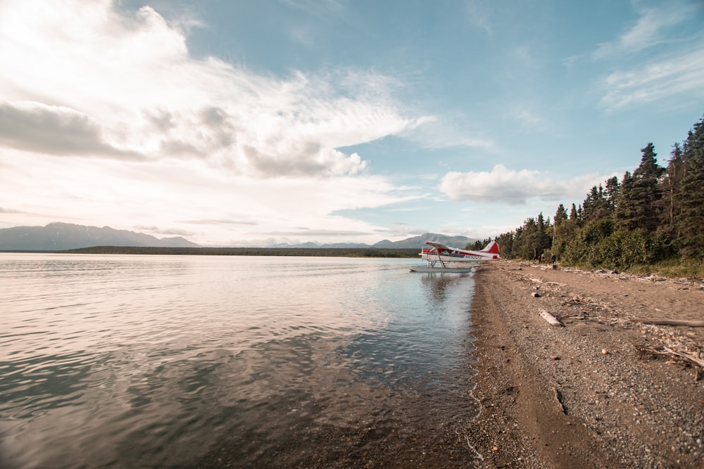 white bi-plane on water