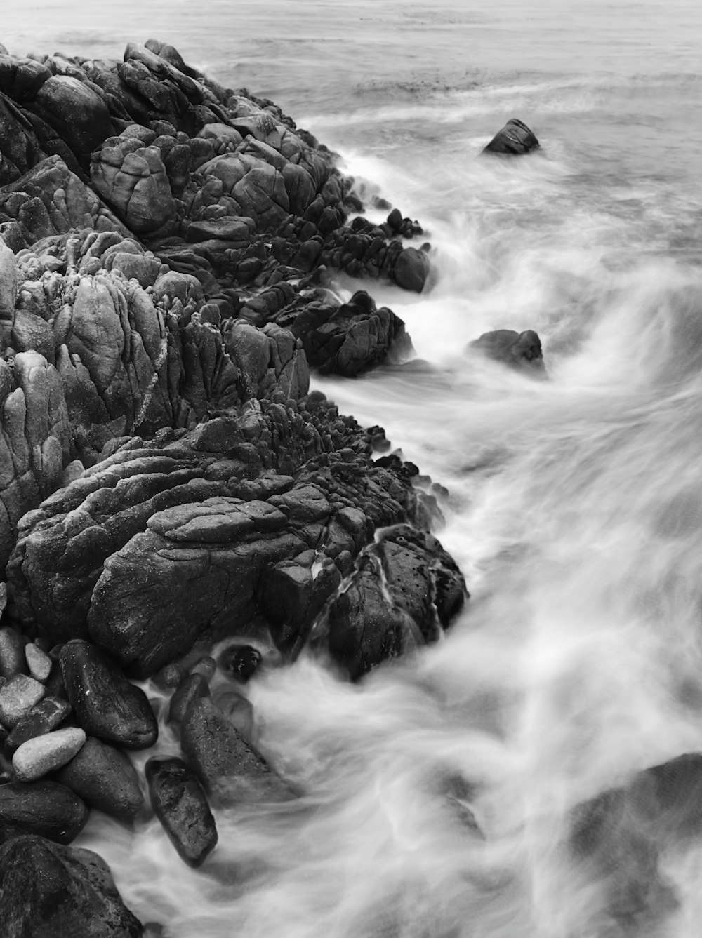 grayscale photography of cliff with ocean waves