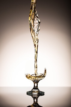 liquid pouring on clear short-stem wine glass