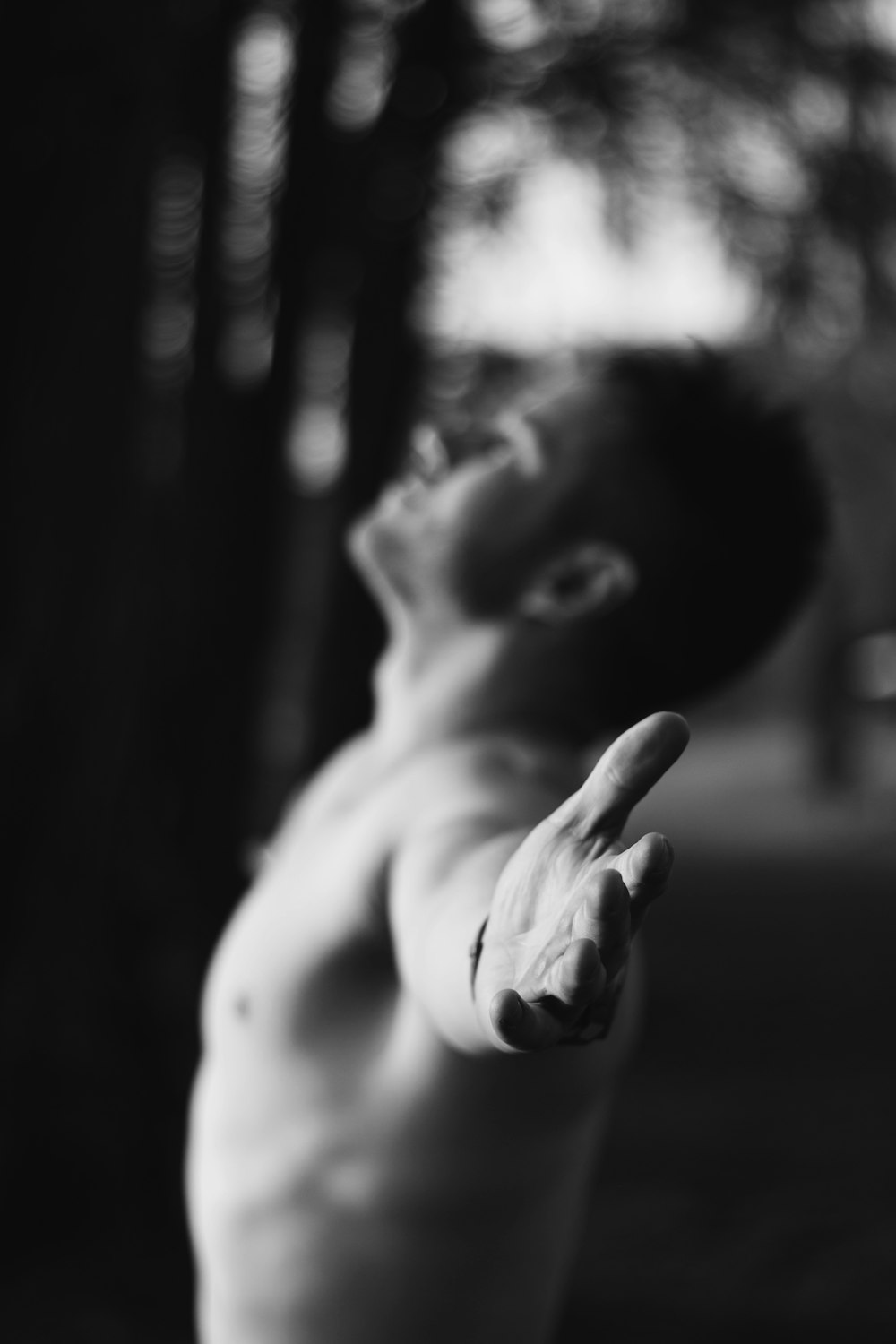 grayscale photo of man forming his hands a cross