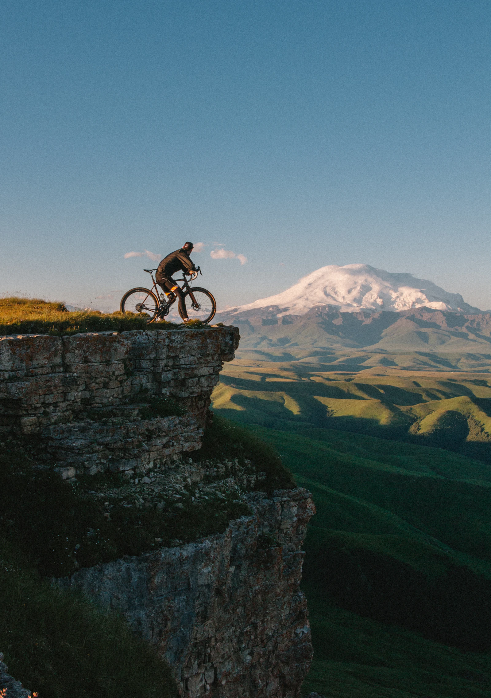 Rennradfahrer auf Bergstraße mit Panorama