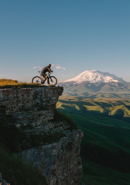 man riding bike on cliff at daytime in Mount Elbrus Russia