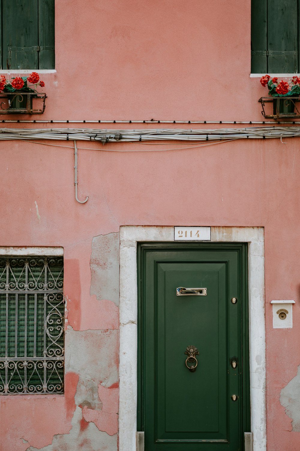 green wooden door in pink concrete building