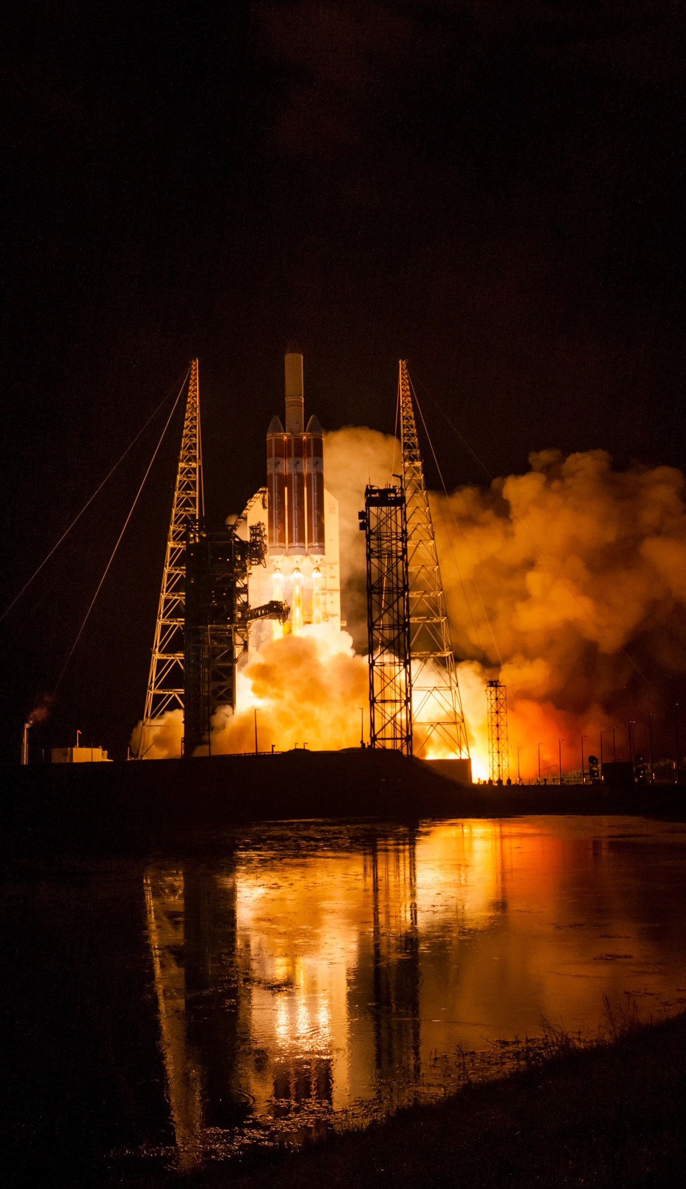 Rocket launching at night with golden flame and smoke
