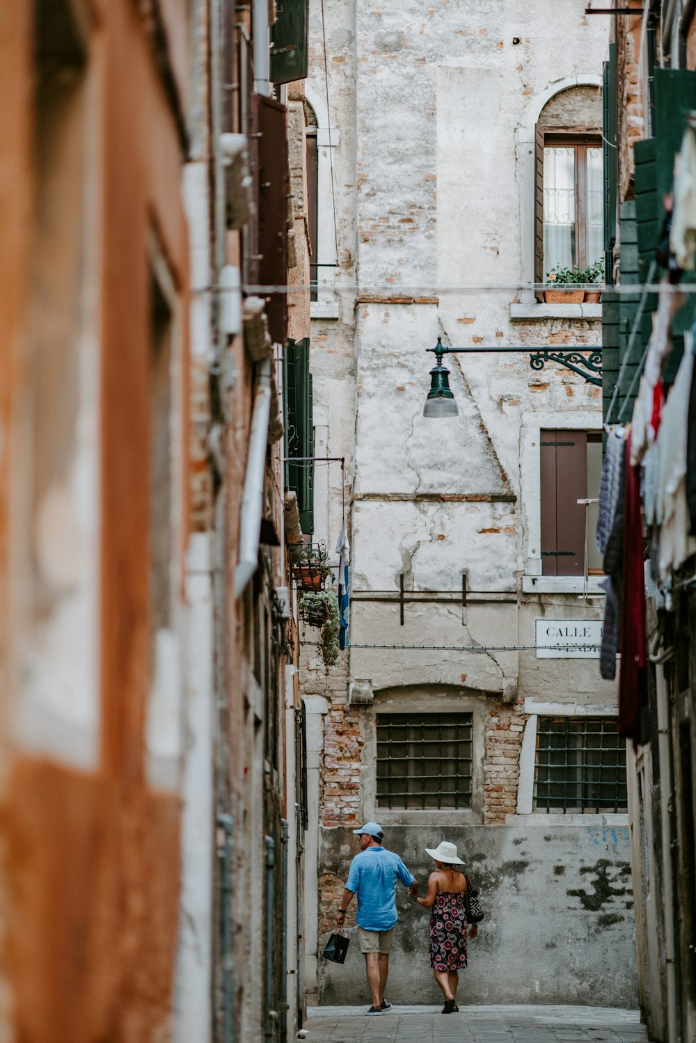 uomo e donna che camminano sulla strada accanto agli edifici