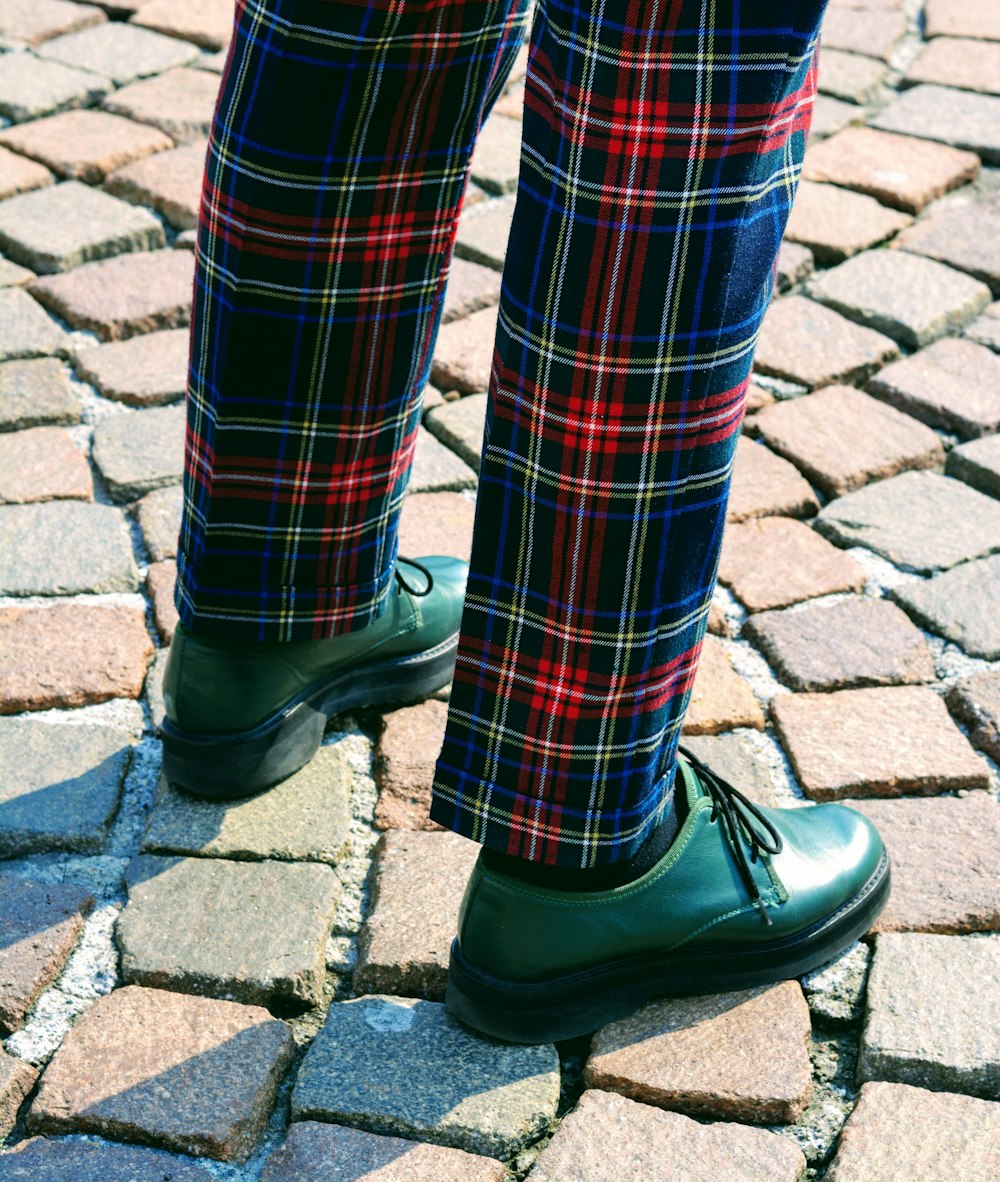 personne portant un pantalon à carreaux bleu, rouge et gris