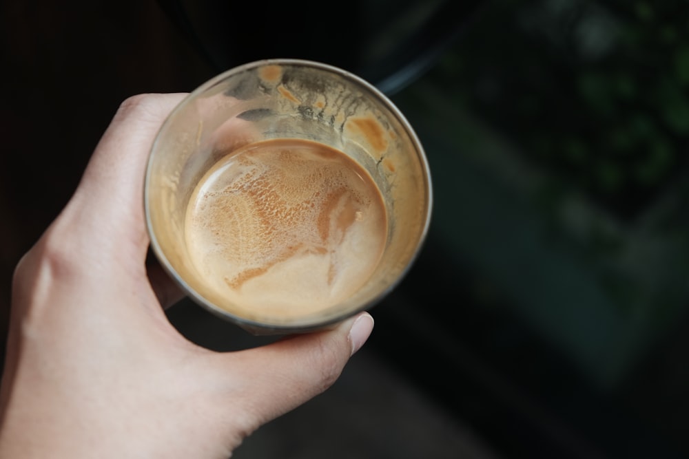 person holding clear glass cup with coffee