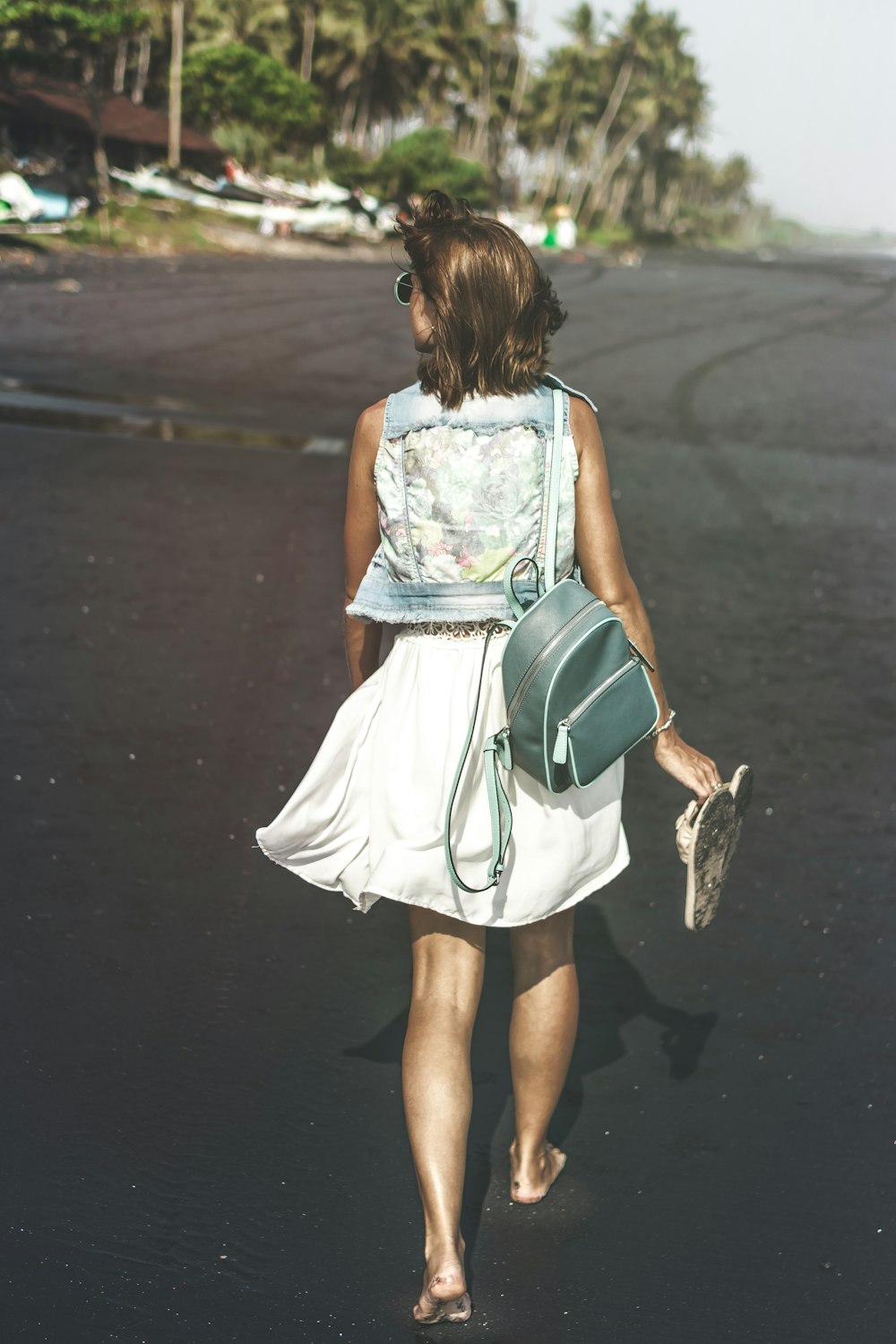 woman carrying her sandals