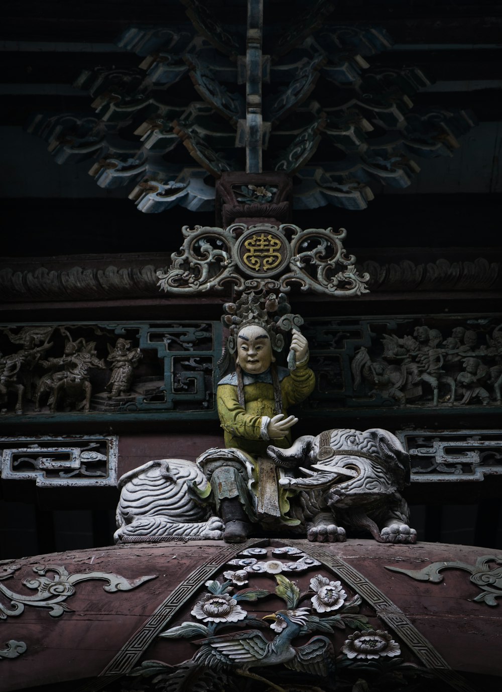 male deity sitting on top of mythical creature statue