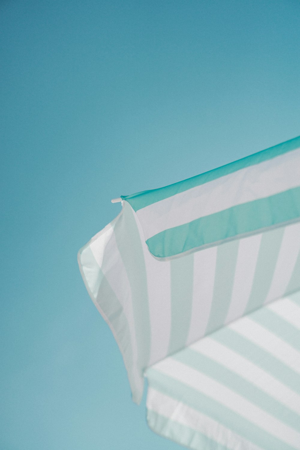 ombrellone a strisce bianche e verdi durante la foto diurna