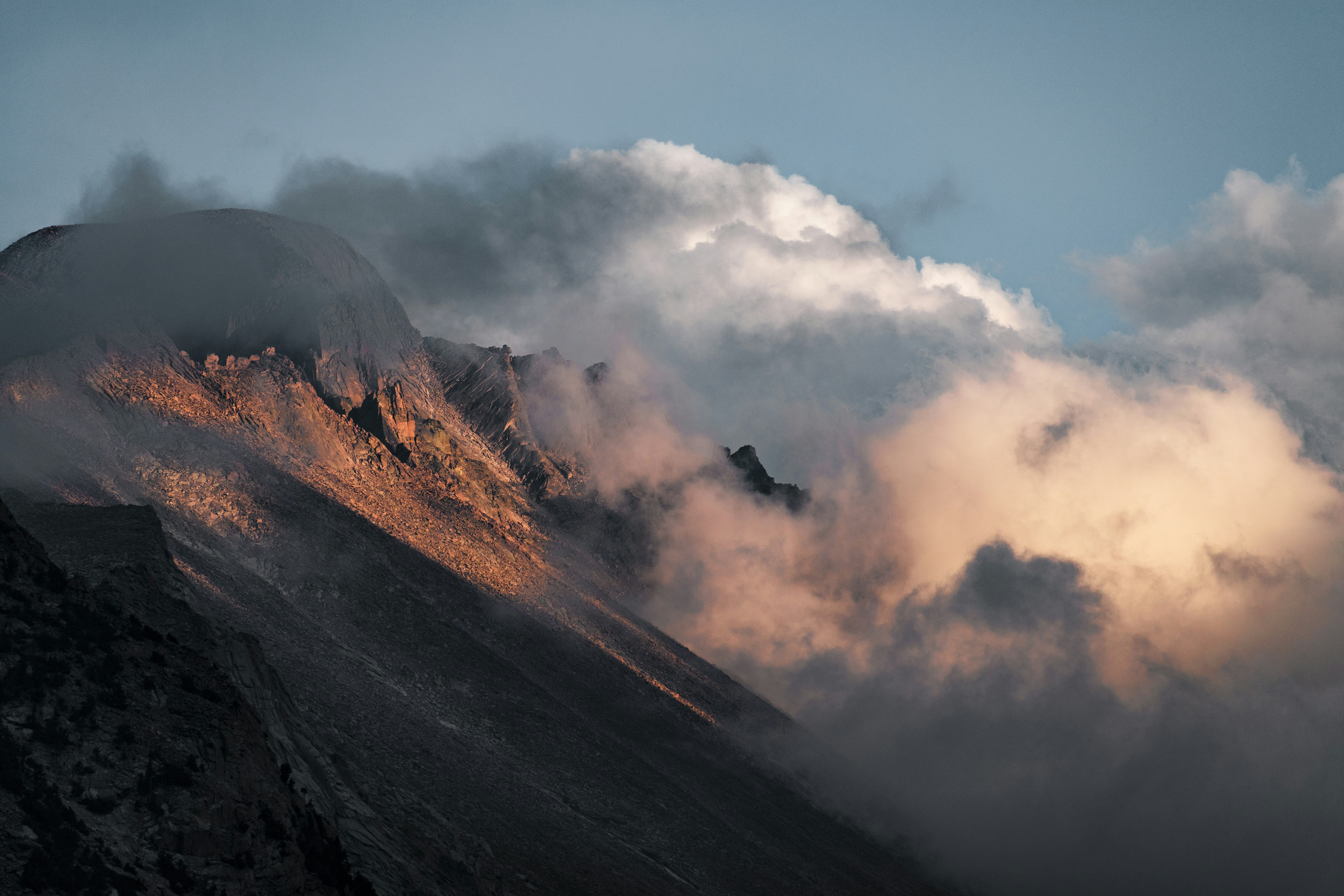 clouds enveloping brown rockhill during daytime, 