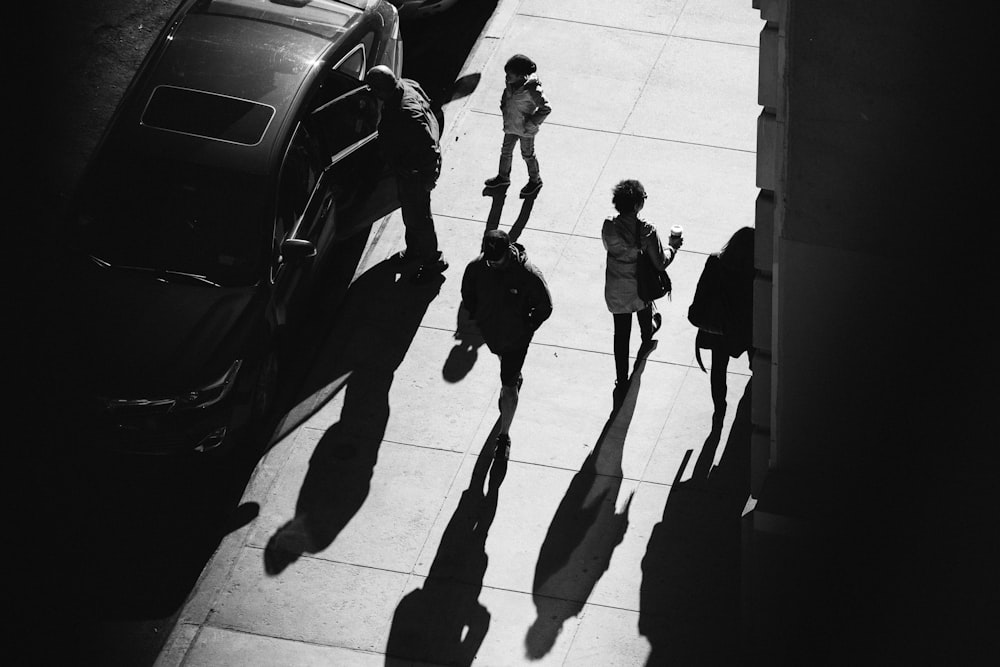 Foto en escala de grises de varias personas caminando por el camino