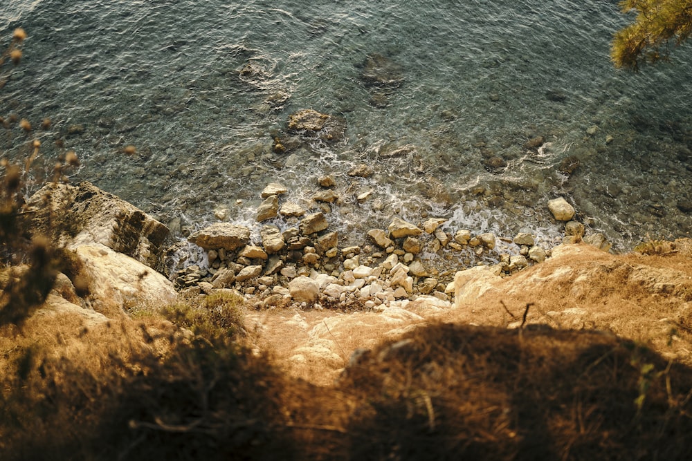 photo of cliff with body of water during daytime