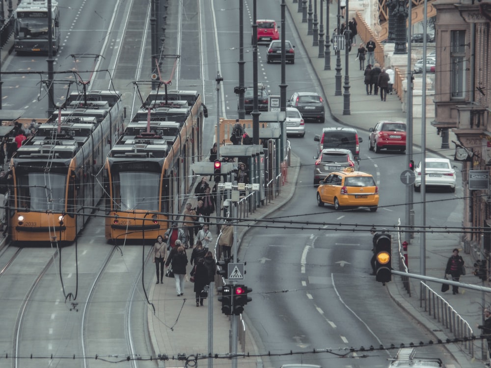 two yellow trams next to road