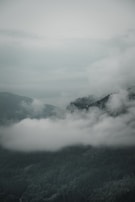 A peaceful mountain view with clouds drifting above the peaks.
