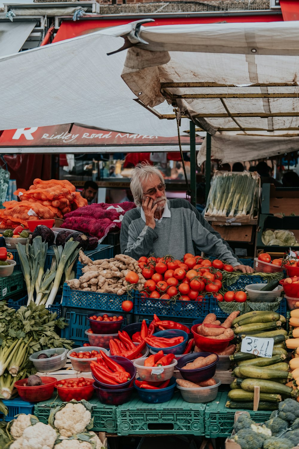 man in gray long-sleeved shirt near tomatoes