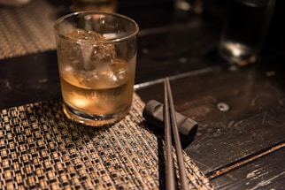 A warmly lit table setting at Golden Ginger with chopsticks resting on a delicate porcelain dish.