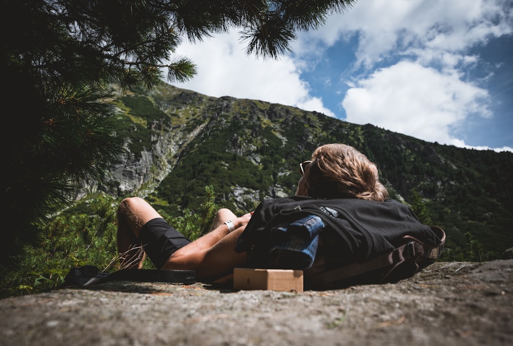 person lying on brown surface under cloudy sky during daytime