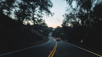 Photo of a winding road disappearing into a sunrise, symbolizing a journey toward financial security.