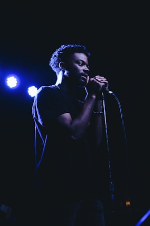 man standing while holding microphone