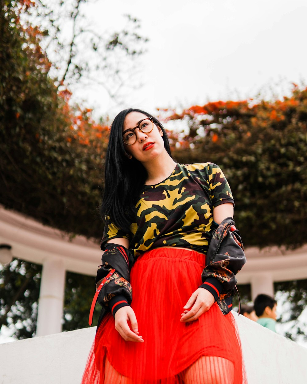 woman in red skirt near trees