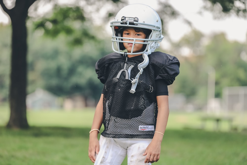 selective focus photography of boy wearing American football gear