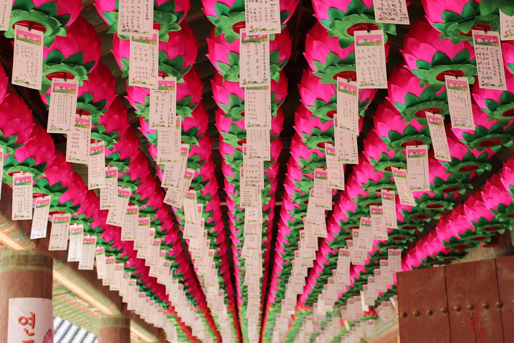 a bunch of paper flowers hanging from a ceiling