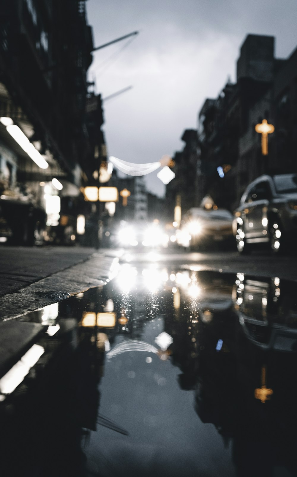 a city street with a puddle of water in the middle of it