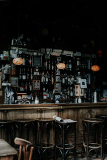 Warm interior shot featuring dark wood textures, glowing pendant lights, and a welcoming bar area